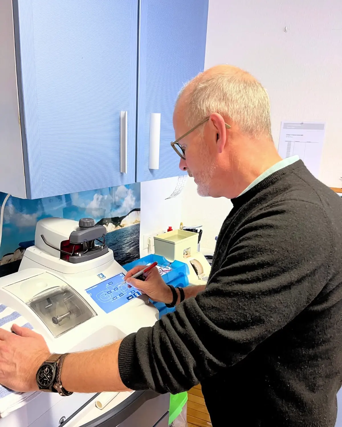 Augenoptiker randet ein Brillenglas in der eigenen Werkstatt